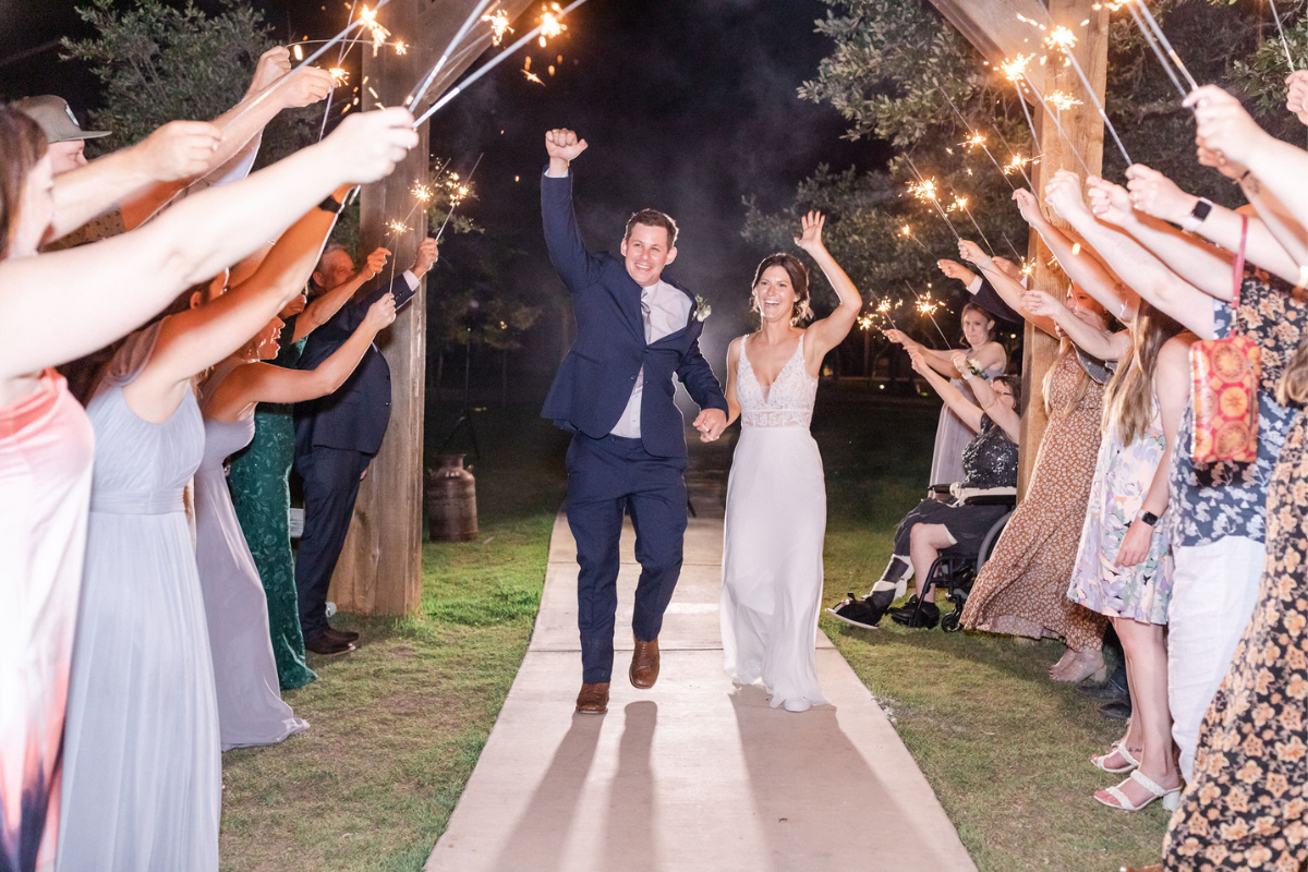 Bride and Groom during sparkler send off cheering with Texas Wedding Ministers