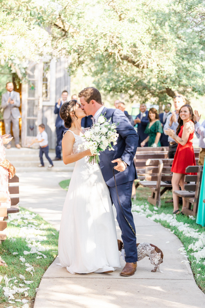 Bride and Groom kissing at the end of the aisle after wedding ceremony with Texas Wedding Ministers