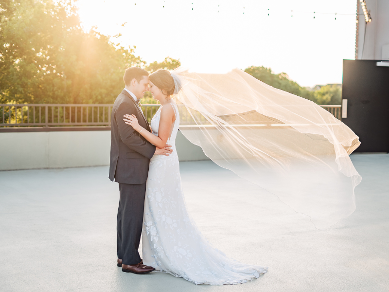 Texas Wedding Ministers couple hugging each other while the bride veil soars in the air